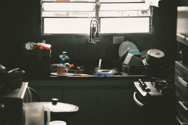 A kitchen sink piled with dishes